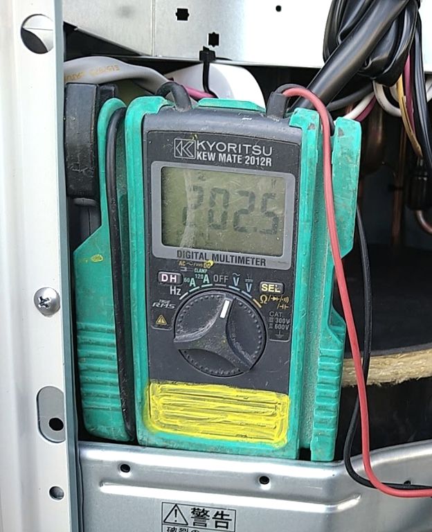 テスターで機器の電源電圧を測る点検作業